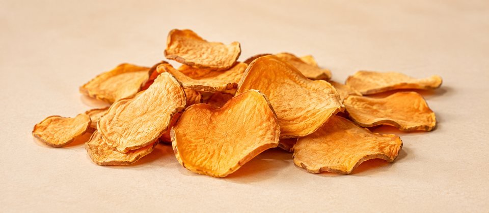 Chips de camote deshidratado apilados, mostrando su textura.